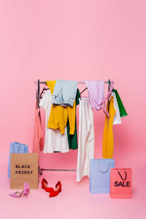 assortment of clothes near footwear and shopping bags with black friday and sale lettering
