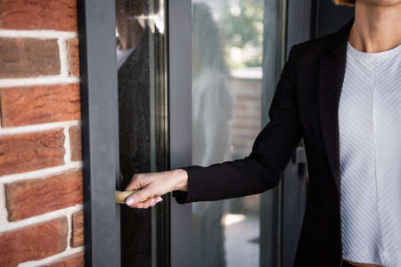 cropped view of realtor opening entrance door in new house
