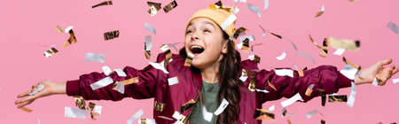 excited preteen girl in stylish outfit smiling near falling confetti on pink, bannerの写真素材