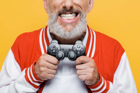 KYIV, UKRAINE - JULY 29, 2021: cropped view of middle aged man in bomber jacket holding joystick and...