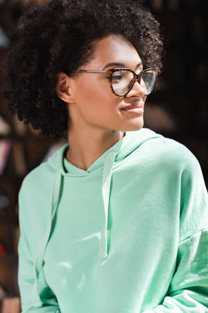 sunshine on face of curly african american student in eyeglassesの写真素材