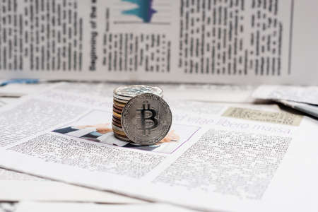 KYIV, UKRAINE - NOVEMBER 1, 2021: metallic bitcoins on printed newspaperの写真素材