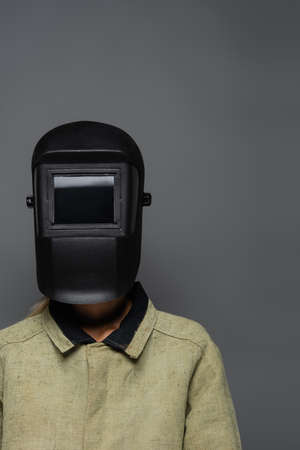 Welder in uniform and helmet with visor isolated on greyの写真素材