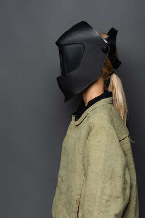 Blonde welder in mask and uniform isolated on greyの写真素材