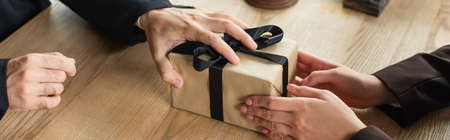 cropped view of client giving gift box to judge, anti-corruption concept, banner