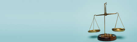 bronze justice scales on blue background with copy space, anti-corruption concept, banner