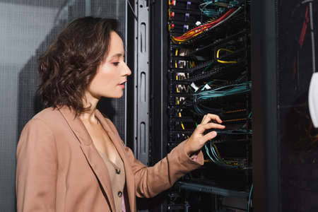 technician checking wires in server while working in data center