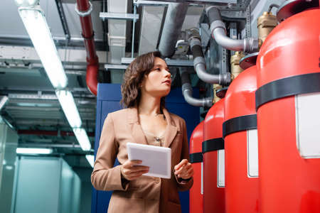 technician with digital tablet checking technical equipment in data center