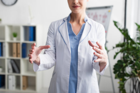 Cropped view of blurred doctor showing something with hands in clinicの写真素材