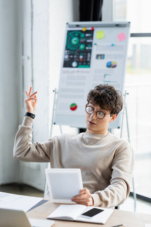 Young transgender person having video call on digital tablet in officeの写真素材