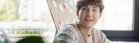 Positive transgender person looking at camera in office, bannerの写真素材