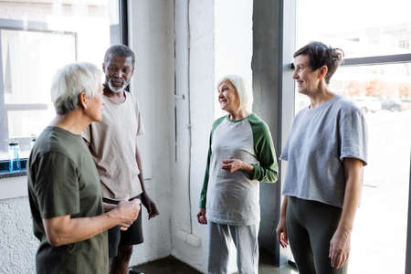 Multicultural senior people talking in sports center