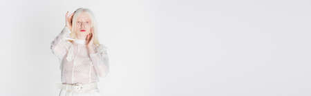 Pretty albino woman holding hands near head isolated on white, bannerの写真素材