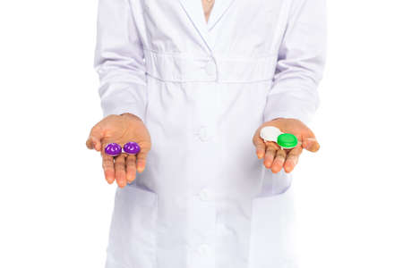 Cropped view of containers with lenses on hands of african american doctor isolated on white