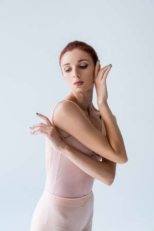 elegant ballerina in bodysuit looking away isolated on greyの写真素材