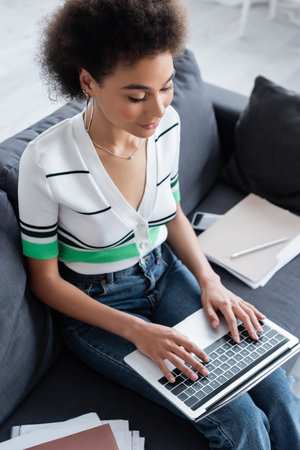 high angle view of african american freelancer typing on laptop keyboardの写真素材