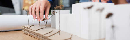 cropped view of architect near house model on desk, bannerの写真素材