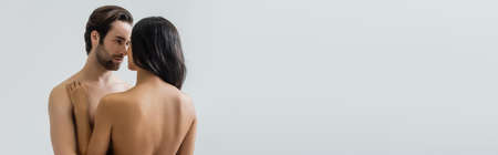 naked couple looking at each other while standing face to face isolated on grey, bannerの写真素材