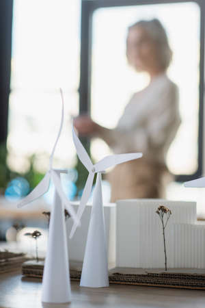 Models of wind turbines and buildings on table in office