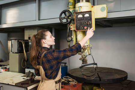 Side view of young welder working with machinery in factoryの写真素材
