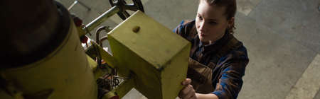 High angle view of welder working with welding machine in factory, banner