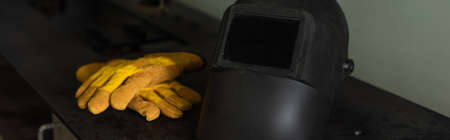 Welding gloves and helmet on table in factory, bannerの写真素材