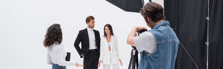 creative director talking to stylish models near photographer working in photo studio, bannerの写真素材