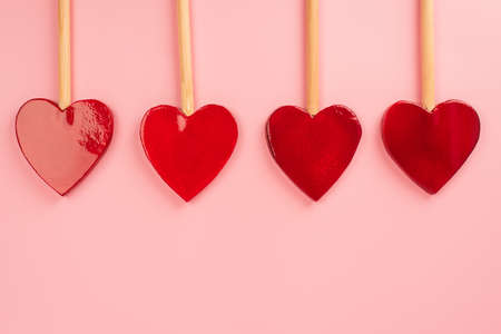 flat lay of heart-shaped lollipops isolated on pink