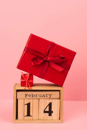 red gift boxes on wooden cubes with 14 february lettering on pinkの写真素材