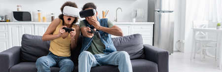 KYIV, UKRAINE - NOVEMBER 9, 2021: Shocked african american couple playing video game and using vr...