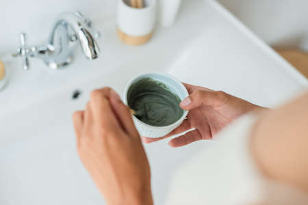 Cropped view of african american woman mixing face mask in bathroom