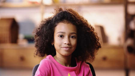 pleased african american girl looking at cameraの写真素材