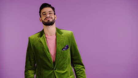 pleased man in green jacket isolated on purpleの写真素材