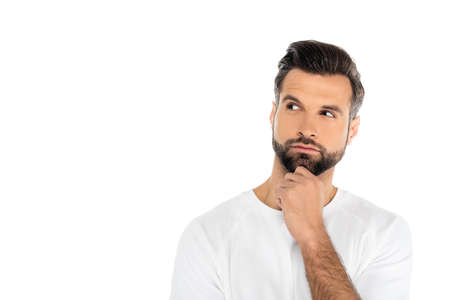 thoughtful man in t-shirt holding hand near chin while looking away isolated on white