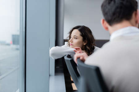 pensive woman looking at window near blurred husband