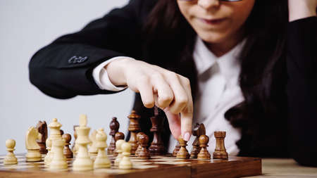 cropped view of businesswoman playing chess isolated on white