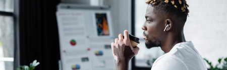 african american man with vitiligo skin and trendy hairstyle drinking coffee to go in office, bannerの写真素材