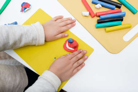Cropped view of kid holding board near plasticine at homeの写真素材