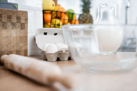 Eggs, blurred rolling pin and milk in kitchen