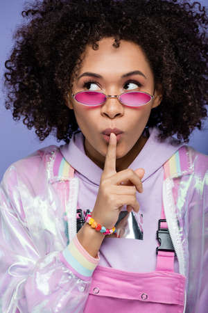 young african american woman showing hush isolated on purple