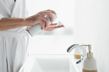 cropped view of man applying shaving foam on hand near sink in bathroomの写真素材