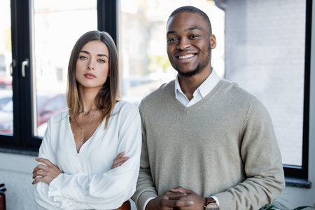 happy african american businessman and pretty businesswoman in office