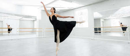 full length view of ballerina dancing during rehearsal in spacious studio, bannerの写真素材