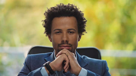 young and confident african american businessman in formal wear looking at camera in office