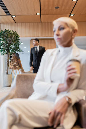 selective focus of african american bodyguard near senior business lady on blurred foregroundの写真素材