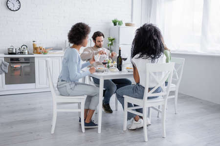 multiethnic friends having pasta during lunch