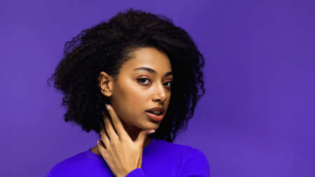 pretty african american woman with curly hair isolated on purpleの写真素材