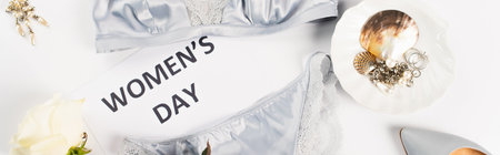 Top view of accessories near lingerie and card with womens day lettering on white background, bannerの写真素材