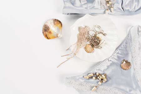 Top view of silk underwear near shells and accessories on white backgroundの写真素材