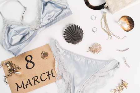Top view of lingerie near bag and card with 8 march lettering on white backgroundの写真素材